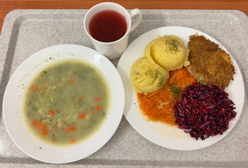 Na zdjęciu znajduje się: Szpinakowa z zacierką,Ziemniaki, Ryba smażona - dorsz, Bukiet jarzyn gotowany z olejem, Kompot owocowy, Sałatka z kapusty czerwonej z olejem